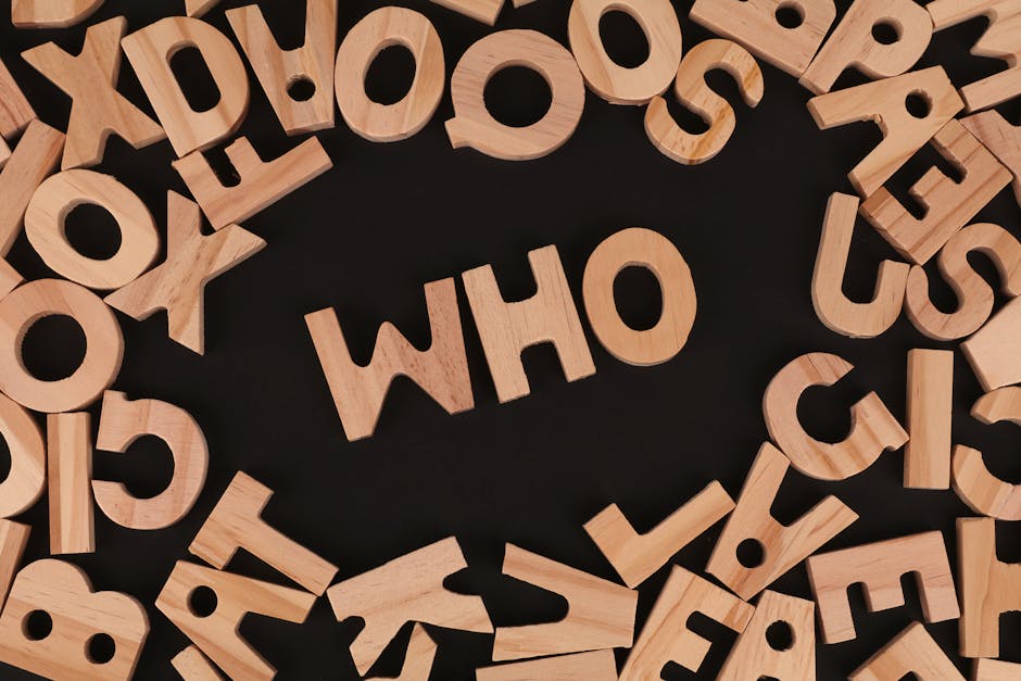 Wooden alphabet letters arranged to spell 'Who' on a black surface, creative message concept.